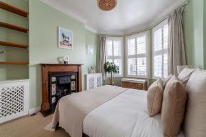 een slaapkamer met een wit bed en een open haard bij The Finsbury Park Collection in Londen