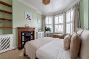 a bedroom with a white bed and a fireplace at The Finsbury Park Collection in London