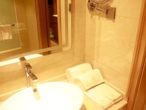 a bathroom with a sink and a toilet and a mirror at SENNA SUNSHINE INTERNATIONAL HOTEL in Sihanoukville