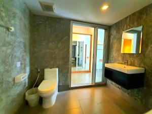 uma casa de banho com um WC, um lavatório e um espelho. em Suite in Replay at Bangrak Beach em Nathon Bay