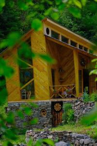 a large wooden cabin with a large window at Korsha Guesthouse in Roshka