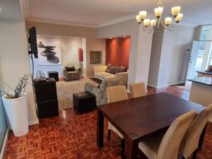 a dining room and living room with a table and chairs at Walk frm Mandela Square, Sandton City and Gautrain in Johannesburg