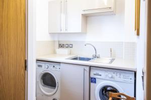 a kitchen with a washing machine and a sink at Waters Edge 05, Amaranth Lodge - P in South Cerney