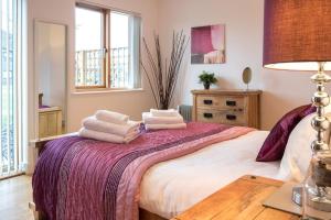a bedroom with a bed with towels on it at Waters Edge 05, Amaranth Lodge - P in South Cerney