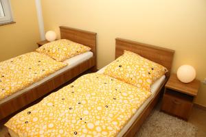 two twin beds in a room with two lamps at Apartments Jadera in Privlaka +5 photos