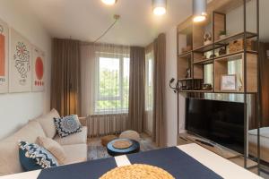 un salon avec un canapé et une télévision dans l'établissement Heart of Sofia Studio, à Sofia
