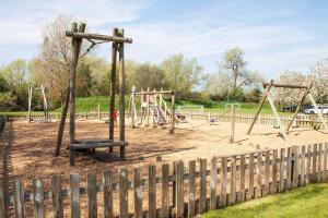 a playground with a swing set in a park at Windrush Lake 66, Sun Kissed Lodge in South Cerney