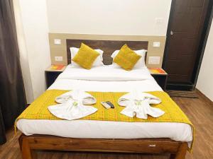 1 dormitorio con 1 cama con toallas en Baga Beach Inn en Baga
