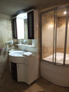 a bathroom with a sink and a shower and a tub at Anatolia cave hotel Pension in Goreme