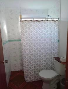 uma casa de banho com um WC e uma cortina de chuveiro em Cabañas amobladas en salto del laja a 2 minutos del puente salto del laja em El Manzano