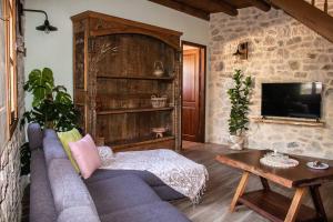 uma sala de estar com um sofá azul e uma televisão em Amygdalia Traditional House em Chania Town