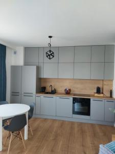 eine Küche mit weißen Schränken und einem Tisch in der Unterkunft La Casa in Piotrków Trybunalski