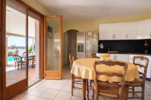 cocina y comedor con mesa y sillas en Maison avec piscine et belle vue, en Lédenon