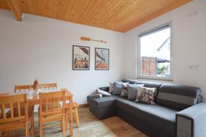 een woonkamer met een bank en een tafel bij Redwood Mielno in Mielno +14 foto's