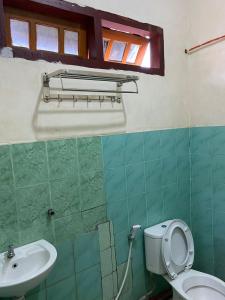 a bathroom with a toilet and a sink at Mawar Bed and Breakfast in Bajawa