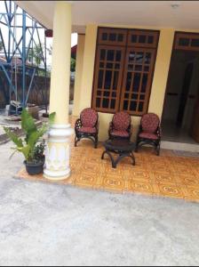 a group of chairs sitting in front of a building at Mawar Bed and Breakfast in Bajawa