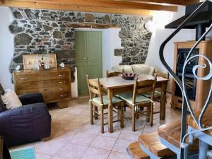 a living room with a table and chairs and a stone wall at HolidHome - Casale Bellavita in San Giovanni Ilarione
