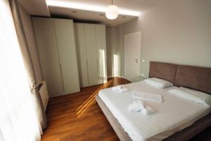 1 dormitorio con 1 cama con 2 toallas en The perfect apartment in Tirana!, en Tirana