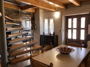 une salle à manger avec une table et un escalier en colimaçon dans l'établissement Casale Bellavita, à San Giovanni Ilarione
