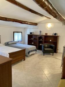 Un dormitorio con 2 camas y una silla. en Casale Bellavita, en San Giovanni Ilarione