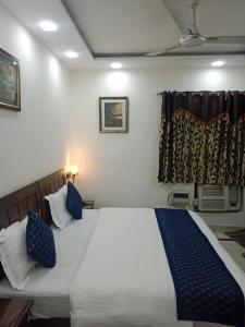 a bedroom with a bed with blue pillows and a window at Yana's B&B nearby Aiims Hospital in New Delhi