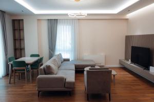 sala de estar con sofá, mesa y TV en The perfect apartment in Tirana!, en Tirana