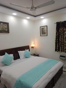 a bedroom with a large bed with blue pillows at Yana's B&B nearby Aiims Hospital in New Delhi