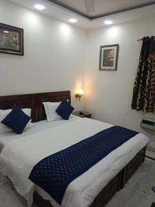 a bedroom with a large bed with blue pillows at Yana's B&B nearby Aiims Hospital in New Delhi