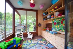 Cette chambre pour enfants dispose de murs en bois et d'une grande fenêtre. dans l'établissement Redwood Mielno, à Mielno