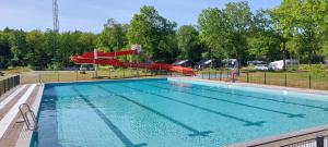 a large swimming pool with a red slide at Mooi Drenthe in Wezuperbrug