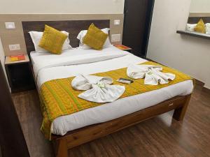 Una cama con toallas blancas encima. en Baga Beach Inn en Baga