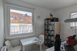 a small kitchen with a white table and a window at Ferienwohnung Bad Vilbel in Bad Vilbel