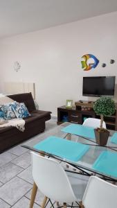 sala de estar con mesa de cristal y sofá en Apartamento Praia Grande, en Praia Grande