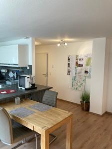 a kitchen with a wooden table and a counter top at Peter's Ferienwohnung Nahe Rust, Kehl, Straßburg, Offenburg in Neuried