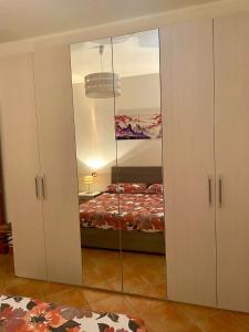 カルデードゥにあるcasa vacanze Ogliastraのベッドルーム(鏡付きのワードローブ、ベッド1台付)