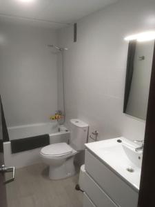 uma casa de banho branca com um WC e um lavatório em Apartamento 1ª linea de mar em Comarruga