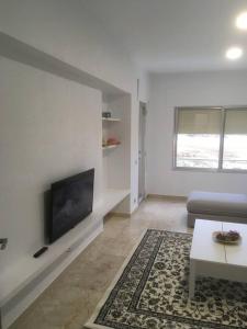ein Wohnzimmer mit einem Sofa und einem Flachbild-TV in der Unterkunft Apartamento 1ª linea de mar in Comarruga