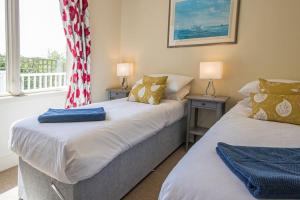 two beds in a room with two lamps and a window at The Landings 18, Waters Reach - P in South Cerney
