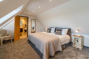 a bedroom with a bed and a chair at Timber Lodge in Tackley