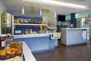 a fast food restaurant with a counter with food at Ibis Budget Grenoble Sud Seyssins in Seyssins