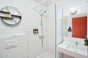 a white bathroom with a shower and a sink at Höfn - Berjaya Iceland Hotels in Höfn