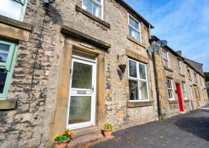 un antiguo edificio de piedra con macetas en una calle en Finest Retreats - Stonelea, en Tideswell