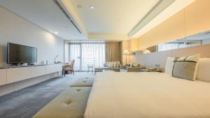 Habitación de hotel con cama grande y TV en CHECK inn SELECT Taichung Dadun, en Taichung