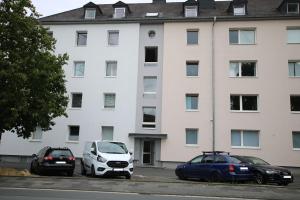 two cars parked in a parking lot in front of a building at Nice Apartment in Wetzlar in Wetzlar
