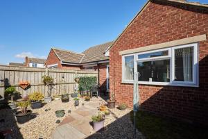 a backyard with potted plants and a fence at Host & Stay - White Rose in Marske-by-the-Sea