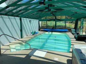 a swimming pool in a building with a roof at Annette's Home in Mazingarbe
