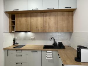a kitchen with white cabinets and a sink at URBAN APARTMENTS PREMIUM, Opolska 10 No 77B, Free Garage, Self Check-in in Katowice