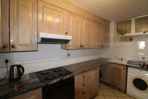 une cuisine avec des armoires en bois et un four à plaques de cuisson dans l'établissement Rondevoux 29, à Margate 18 autres photos