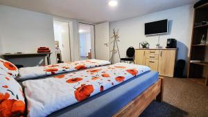 Un dormitorio con una cama con flores naranjas. en Treffpunkt Heuwiese en Weite