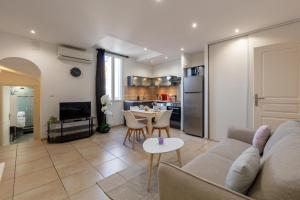 ein Wohnzimmer mit einem Sofa und einem Tisch in der Unterkunft Coeur de Provence - Appt climatisé in Draguignan
